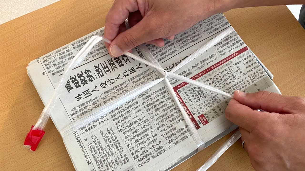 新聞紙を外科結びでまとめた写真